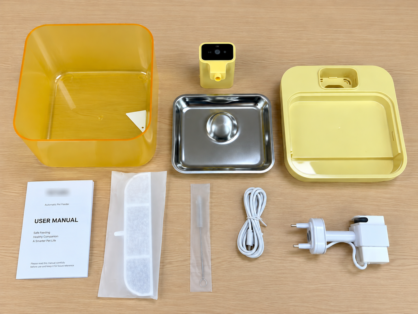 Yellow automatic pet feeder components with stainless steel tray, user manual, cable and power adapter